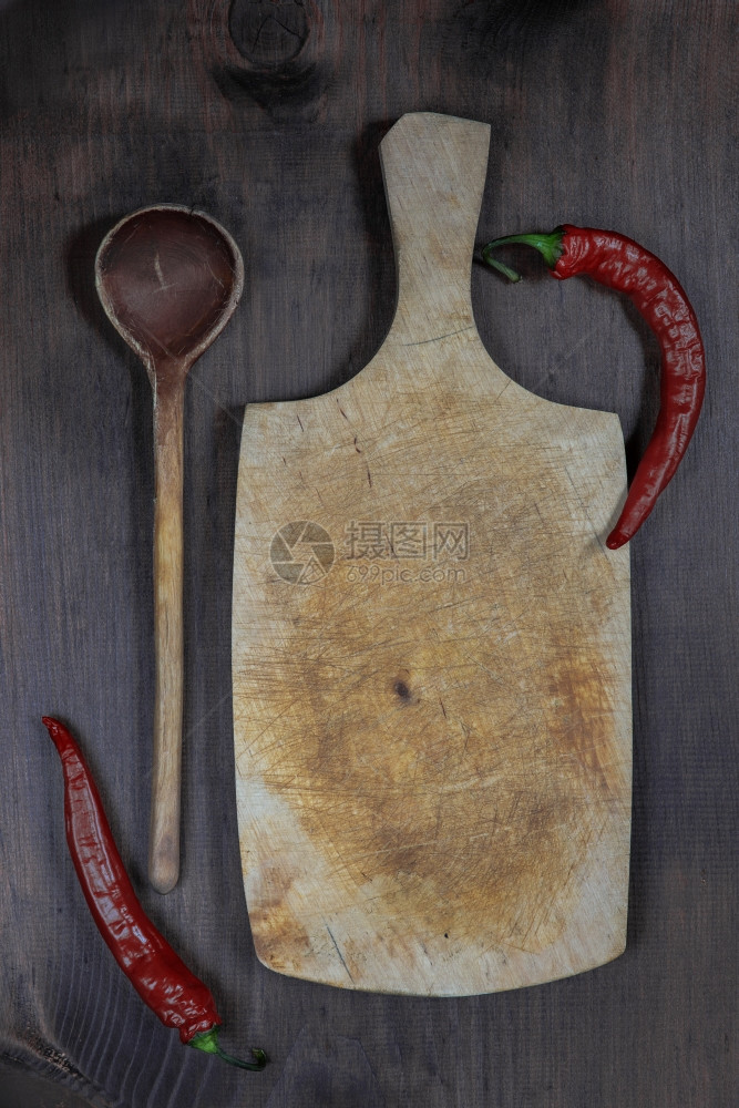 配有红辣椒和木勺的老式切板图片