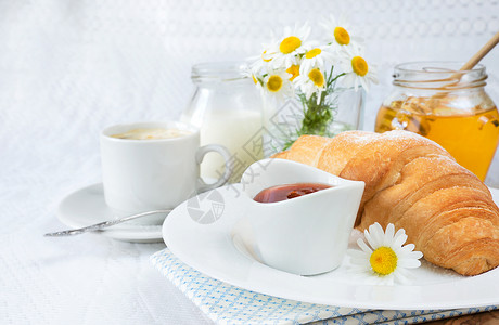 带羊角面包咖啡果酱和蜂蜜的大陆早餐图片