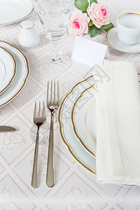 漂亮的装饰桌上面有白色板水晶眼镜餐具和豪华桌布花并挂有宾卡图片