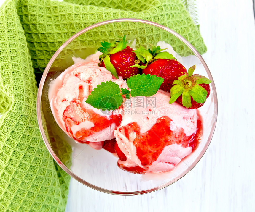 草莓薄果糖浆和的玻璃杯中草莓冰淇淋顶上背景浅木板的餐巾纸图片