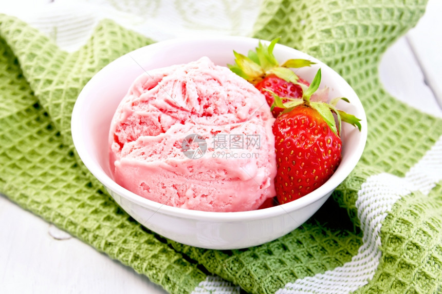 白碗中草莓冰淇淋在木板背景上的餐巾纸加草莓图片