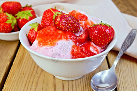 白碗中的草莓勺子木板上的餐巾纸和草莓白碗中的冰淇淋背景图片