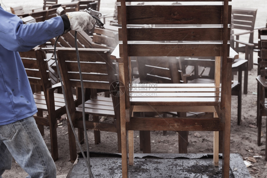 工人拿喷水枪在清洗修理木椅图片