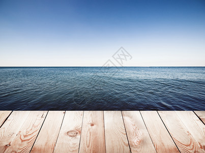 蓝海和天空背景上的木尖码头图片
