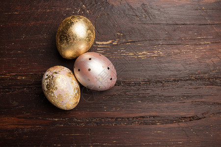 棕色木桌上金色的三颗鸡蛋图片