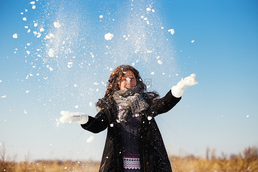 年轻女士在美丽的冬日开心玩雪景图片