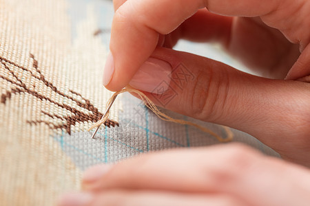 手缝线女人用手做交叉针刺贴近绣背景