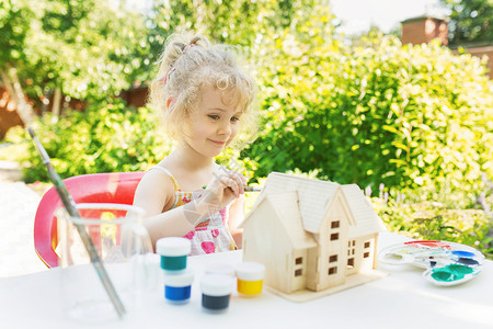 小女孩画木制房屋模型图片