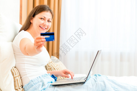 女孩坐在沙发上展示信用卡图片