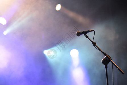 在摇滚音乐会上用有彩色灯光的麦克风聚灯背景图片