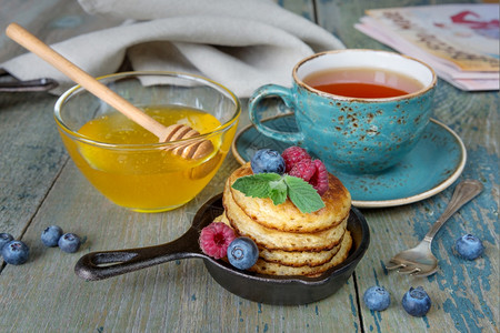 煎锅饼早餐新鲜果子蜂蜜和黑茶图片