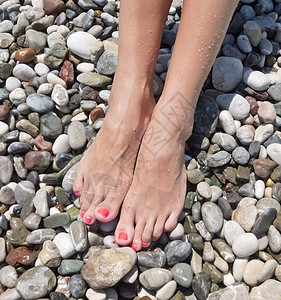 女人双腿在海边的石块上图片