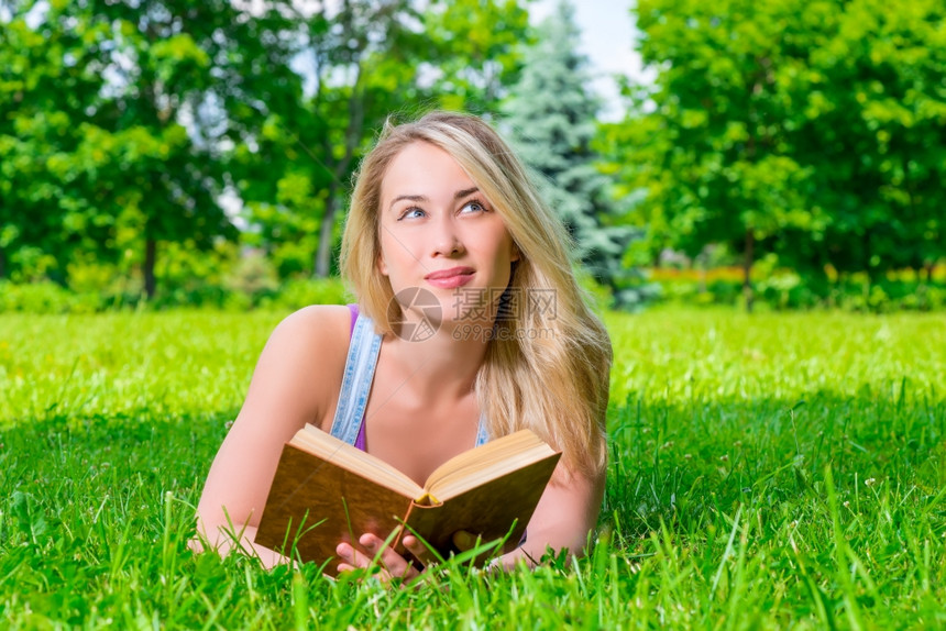 趴在草地上看书的女孩图片