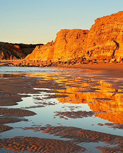 日落时海面上悬浮着岩石海岸高清图片