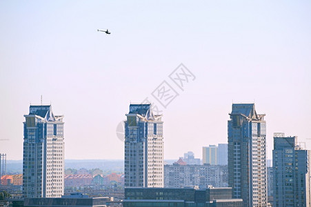直升机在现代建筑物上空飞行图片