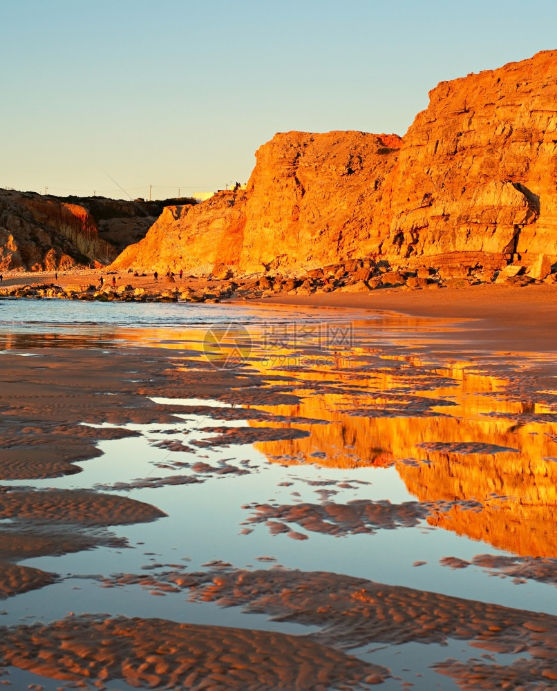 日落时海面上悬浮着岩石海岸图片