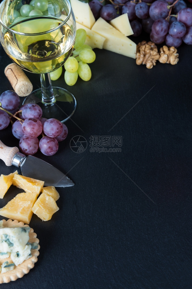 白葡萄酒各种类的奶酪胡桃和黑板石本底的葡萄图片