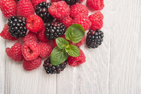 木桌背景上成熟的甜莓果和黑高清图片