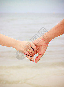一对情侣在海滩上手牵手图片