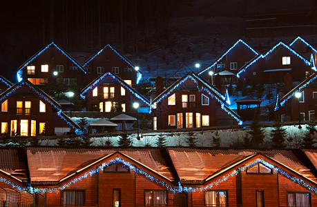 夜间滑雪度假胜地新年装饰的木屋图片
