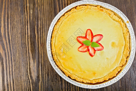 草莓蛋糕加奶油酱草莓和薄荷在顶部的黑木板上面粉状图片