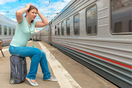 她迟到的火车路过而沮丧的女人图片