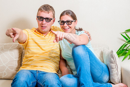 在沙发上用3D眼镜看电视的情侣图片