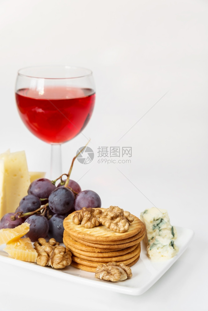 白瓷板上底瓷板上的各种奶酪葡萄饼干和胡桃图片