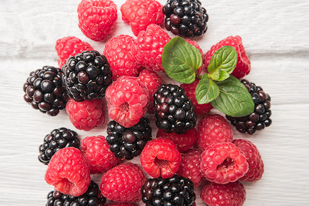 木桌背景上成熟的甜莓果和黑高清图片