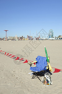 在阳光明媚的科尼岛海滩上带毛巾的空椅子等待保姆回来图片