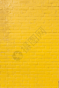 亮黄色油漆砖块墙的垂直部分背景图片