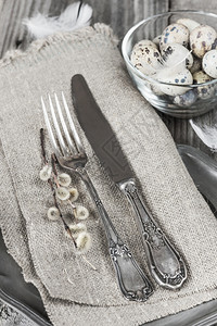 粗餐巾纸柳树枝和一个玻璃碗中的蛋上古老餐具图片