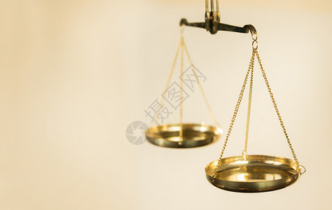 两碗金属制成的天秤悬在金色底的铁链上背景图片