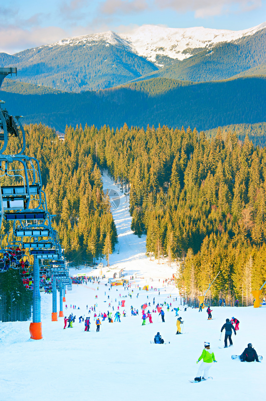 人们在滑雪度假胜地的斜坡上滑雪和图片