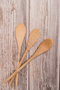木制勺子绑在生锈背景的丝带上面有复制空间背景图片