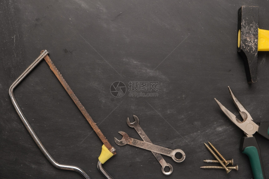 一组锯子钳螺钉和锤工具在木板上方顶部视图带有复制空间图片