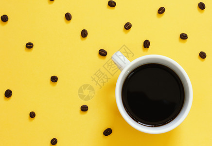 黄色背景的黑咖啡和豆图片