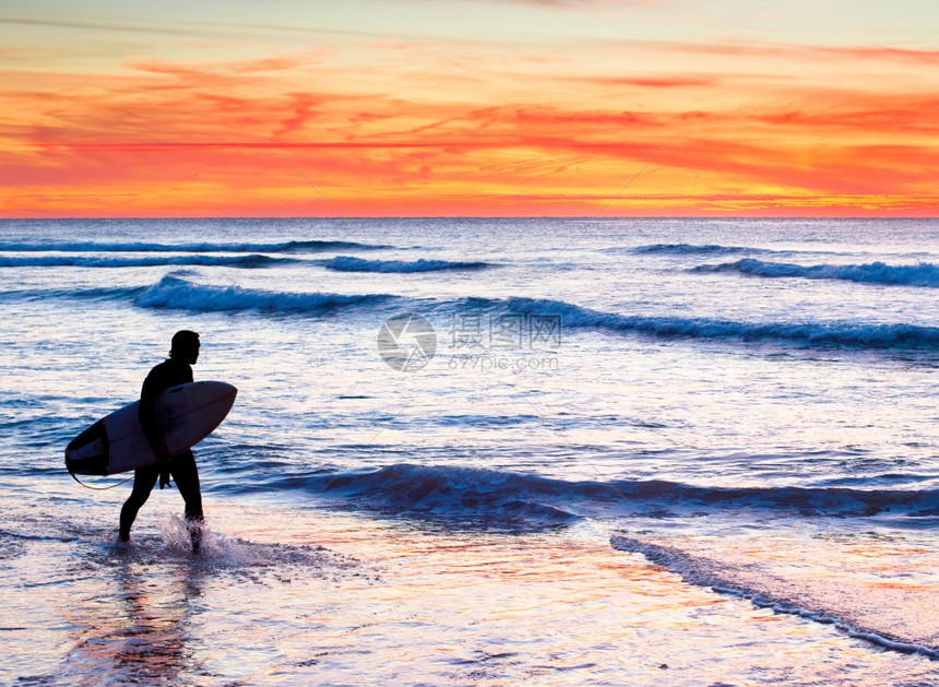 日落时在海中冲浪板的不明器图片