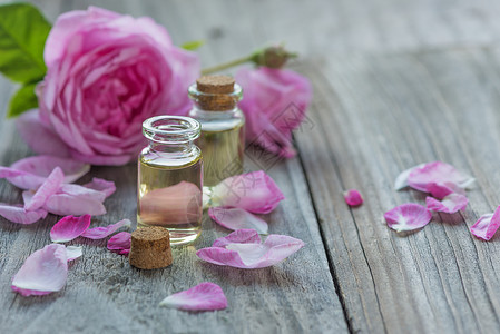 粉红玫瑰花与精油放在桌上高清图片