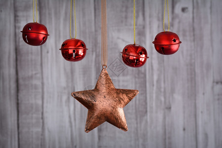 圣诞星和挂在绳子上的红色球在木制背景下的特写镜头图片