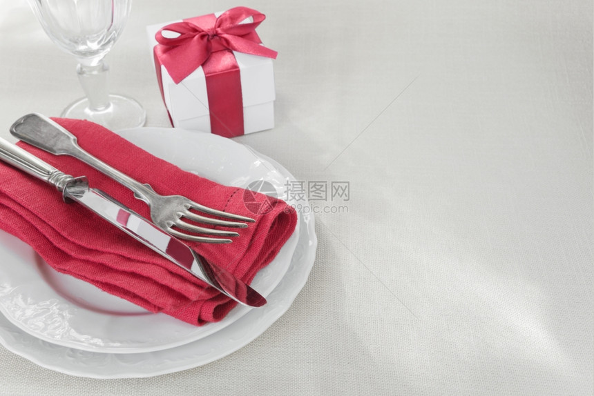 美的装饰桌有白色板礼品盒桌布上有红色丝带餐具和酒杯有文字空间图片