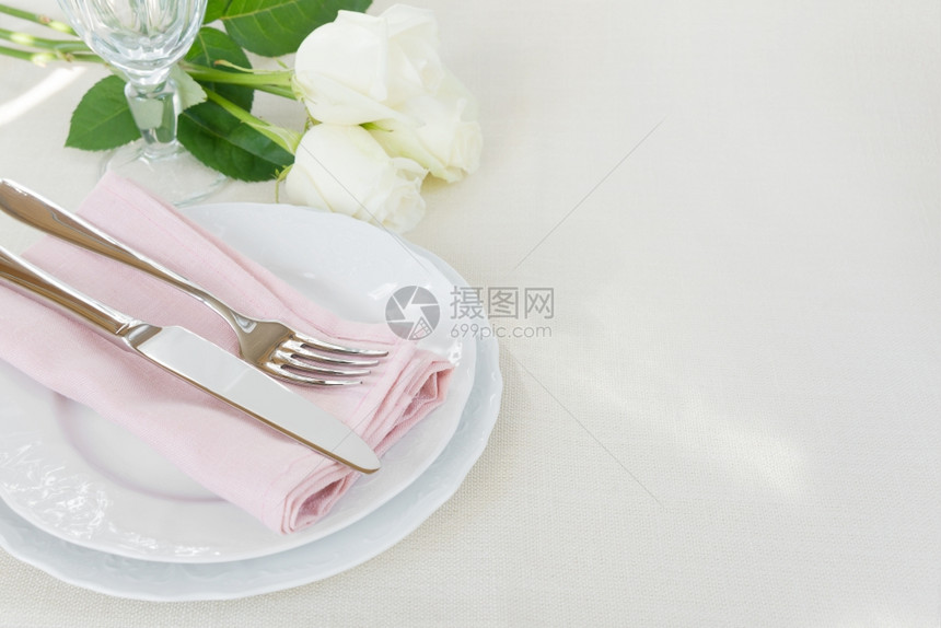 桌布上花朵和白有文字空间的美丽装饰桌上面有白色板晶玻璃粉面餐巾具和白玫瑰花有文字空间图片