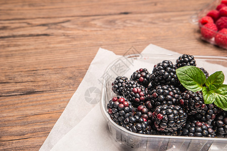 木桌背景上成熟的甜黑莓和草高清图片