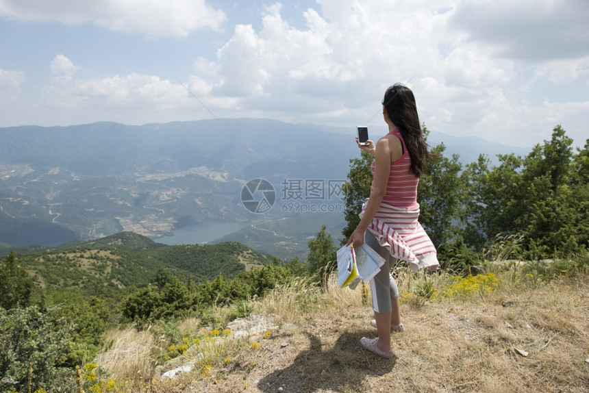 妇女在森林里用智能手机拍照图片