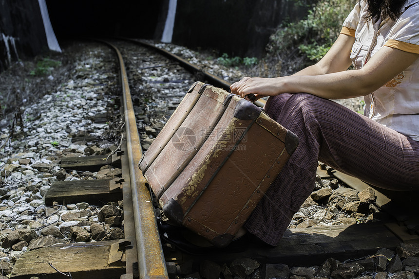 铁路公和隧道上的女用旧手提箱和图片