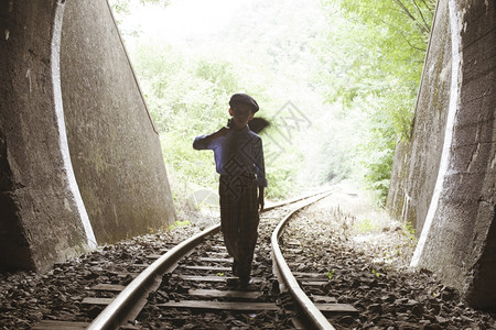 儿童在铁路上行走与古老的siutcae图片