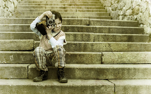儿童拿着复古的相机坐在楼梯上牌照图片