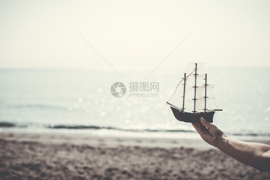 模特举着帆船在沙滩上图片
