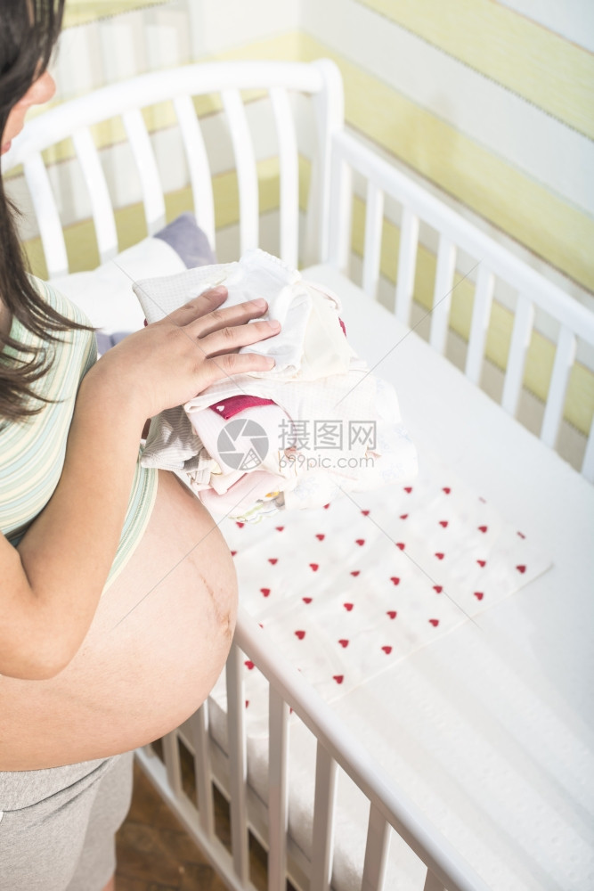 孕妇在为婴儿准备房间图片