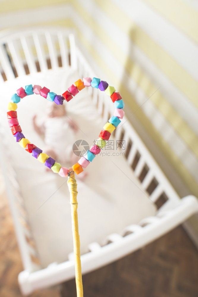 婴儿在以心脏形状为框架的床上图片